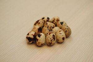 Quail eggs on a wooden background. Close-up, selective focus. photo
