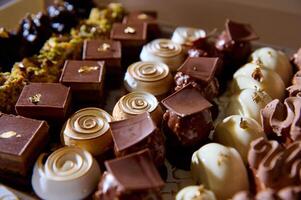 Assortment of gourmet pastries and chocolates on display at a bakery photo