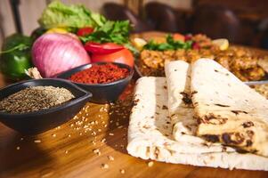 Fresh ingredients and spices in a vibrant kitchen setting with delicious flatbreads and a variety of colorful vegetables, herbs, and spices for a perfect culinary experience photo