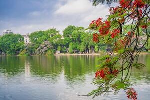 Hoan Kiem lake or Sword lake, Ho Guom in Hanoi, Vietnam with Turtle Tower, on clear day with blue sky and white clouds photo