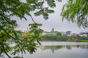 Hoan Kiem lake or Sword lake, Ho Guom in Hanoi, Vietnam with Turtle Tower, on clear day with blue sky and white clouds photo