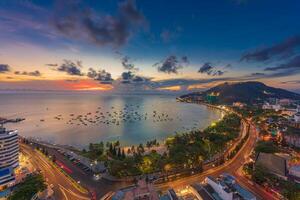 Top view with beautiful sunset and boats. Panoramic view of Vung Tau coast from above with waves, beach, streets, coconut trees and Tao Phung mountain in Vietnam photo