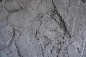 The gray texture of the stone. The cracked layered surface of the mountain. Close-up. Grey stone background with space to copy photo
