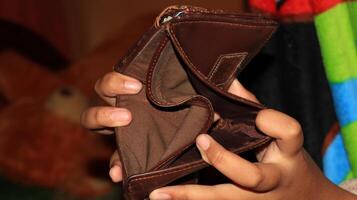 An Empty wallet in the hands of a young photo