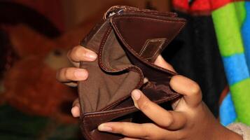 An Empty wallet in the hands of a young photo