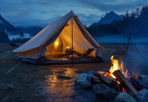 A cozy scene with a tent illuminated from within and a campfire providing warmth outside photo