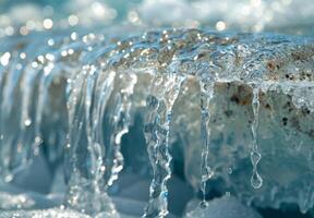 A close up of a melting glacier with clear water dripping down its surface photo