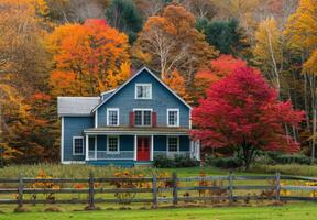 A quaint New England farmhouse with a backdrop of colorful fall foliage photo