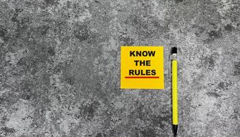 Concept of Know The Rules write on sticky notes isolated on Wooden Table. photo