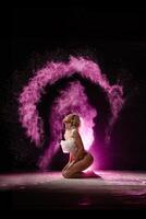 Woman posing with pink particles sprayed in air photo