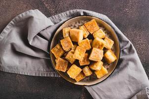 Close up of deep fried vegetarian soy tofu cheese on plate on table top view photo