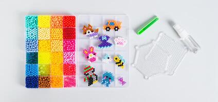 A box with aqua beads and tools for creating a decor top view web banner photo