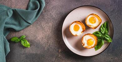 Baked egg and bacon rolls with basil on a plate on a table top view web banner photo