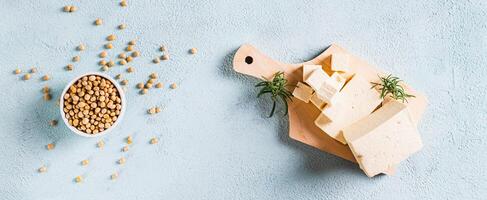 Organic vegetarian soy tofu and rosemary on wooden board on table top view web banner photo