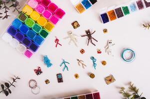 Miniature beaded toys, wire and boxes with colorful beads on a table top view photo