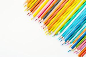 Office for school classes or art classes. Colored pencils arranged in a row on a white background in close-up. photo