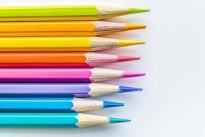 Office for school classes or art classes. Colored pencils arranged in a row on a white background in close-up. photo