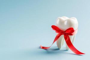 a tooth with a red ribbon on a blue background. A concept for a dentist. A place for the text. photo