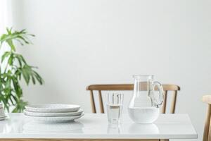 Water in a jug and a glass on the table, a chair and furniture, dishes on a white wall background. Advertisement. Style. photo