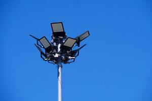 High-Powered Stadium Floodlights Against Clear Blue Sky on a Bright Sunny Day photo