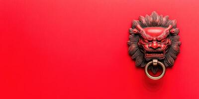 Vintage decorative lion head door knocker on a vibrant red wall, symbolizing strength and protection in traditional Asian art and architecture. photo