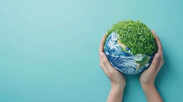 Hands holding the Earth with green foliage, symbolizing environmental protection and sustainability against a teal background. photo