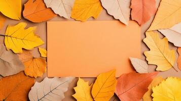 Autumn-themed background with a blank orange card surrounded by colorful fall leaves, perfect for seasonal messages and designs. photo