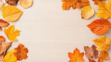 Autumn leaves arranged in a border on a light wooden background. Perfect seasonal image for fall, thanksgiving, and autumn-themed projects. photo