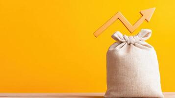 A burlap sack with an upward arrow against a yellow background, symbolizing growth or financial success. photo