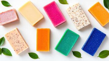 Colorful artisanal soaps arranged neatly on a white background, surrounded by fresh green leaves. Perfect for a spa or skincare theme. photo