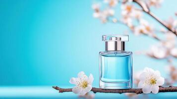 Beautiful blue perfume bottle surrounded by delicate flowers on a branch, evoking freshness and elegance. photo