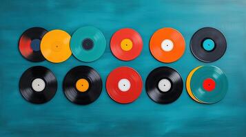Colorful vinyl records arranged on a teal background, perfect for music lovers and vintage enthusiasts. photo