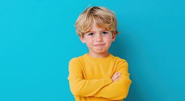 Cheerful boy with blonde hair standing confidently against a vibrant blue background, showcasing a playful and expressive personality. photo