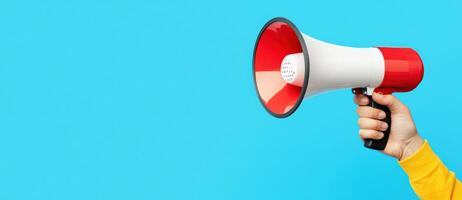 A vibrant image of a person holding a megaphone against a bright blue background, symbolizing communication and outreach. photo