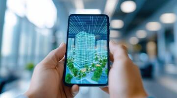 A person holds a smartphone displaying a 3D architectural model of a modern building in a bright office space. photo