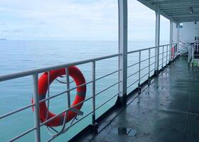 Serene Ocean View from a Ferry Deck with Safety Lifebuoy and Calm Waters Under a Cloudy Sky photo