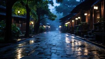 A wet cobblestone street lit by lanterns in a dimly lit town at night. photo
