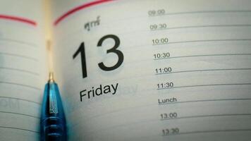 Close-Up of Calendar Showing Friday the 13th with Blue Pen on Schedule Page photo