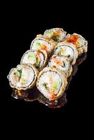 hot sushi roll tempura with salmon cream cheese cucumber avocado unagi on a black mirror background photo