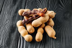 sweet and sour tamarind on a black rustic wooden background photo