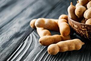 sweet and sour tamarind on a black rustic wooden background photo
