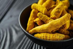 aromatic turmeric root on a black wooden rustic background photo