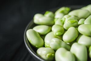 fresh greens broad beans fava on a dark background photo