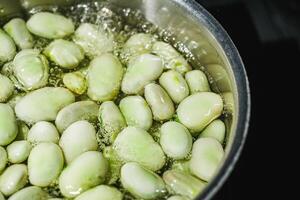 fresh greens broad beans fava boiled on a dark background photo