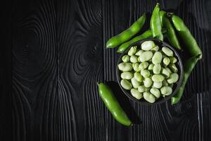 fresh greens broad beans fava on a dark background photo
