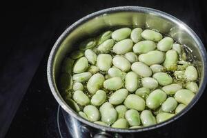 fresh greens broad beans fava boiled on a dark background photo