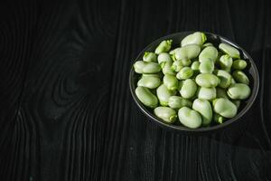 fresh greens broad beans fava on a dark background photo