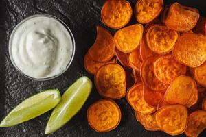 sweet potato chips on a dark wooden rustic background photo