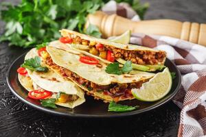 set of delicious fresh colorful quesadilla on a dark background photo