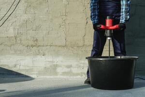 the builder mixes the cement mixture with a mixer photo